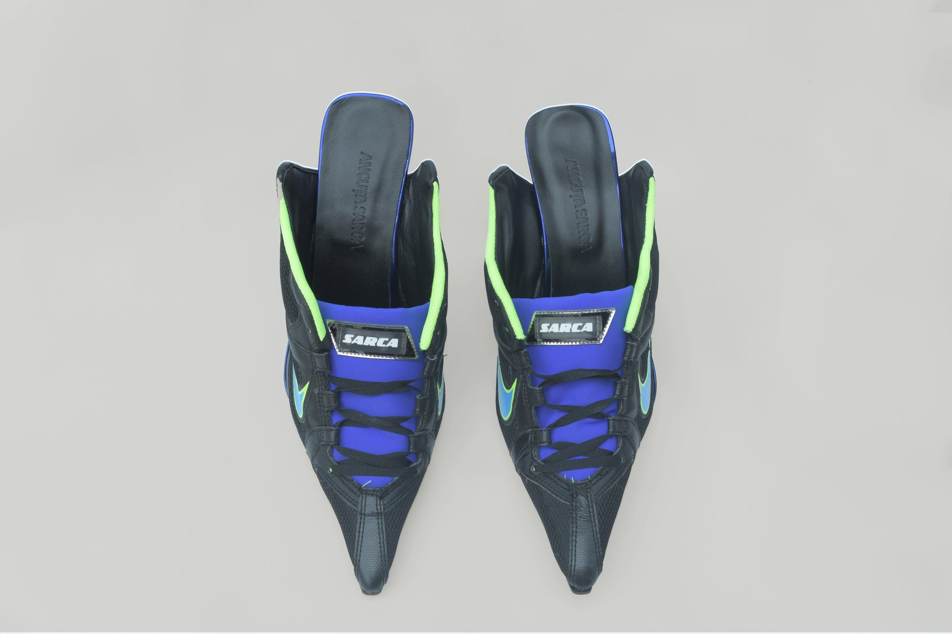 A photograph of the top view of a pair of Ancuta Sarca Olympia Heel Black shoes, WITH BLUE AND GREEN DETAILS, FRONT LACE-UP FASTENING, POINTED TOE, SLIP-ON STYLE, MADE IN ITALY