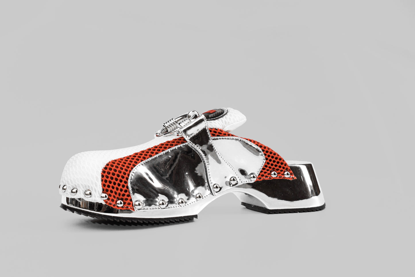 A photograph of the diagonal view of Ancuta Sarca Beetle Clog Mirror, MIRROR FINISH, MESH PANEL WITH RING EMBELLISHMENT, LOGO PATCH AT TONGUES, BRANDED FOOTBEDS, ROUND TOES, SILVER TONE HARDWARE, MADE IN ITALY