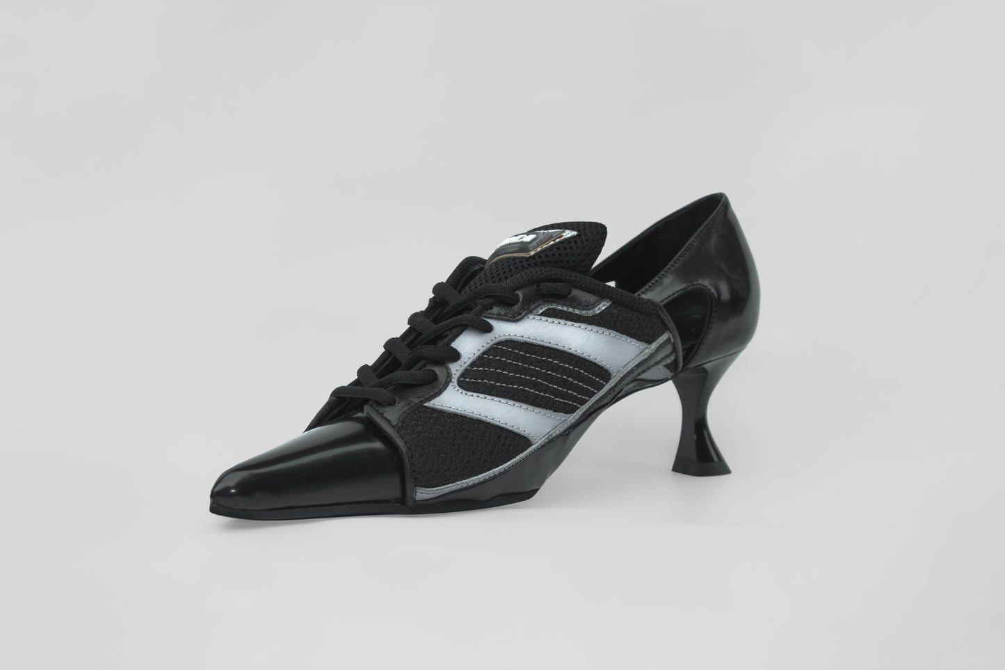 A photograph of the diagonal view of Ancuta Sarca Lamborghini Heel Black, 6CM HEEL, UPCYCLED TRAINER CLOSED BACK PUMPS, POINTY TOE, BLACK FAUX LEATHER