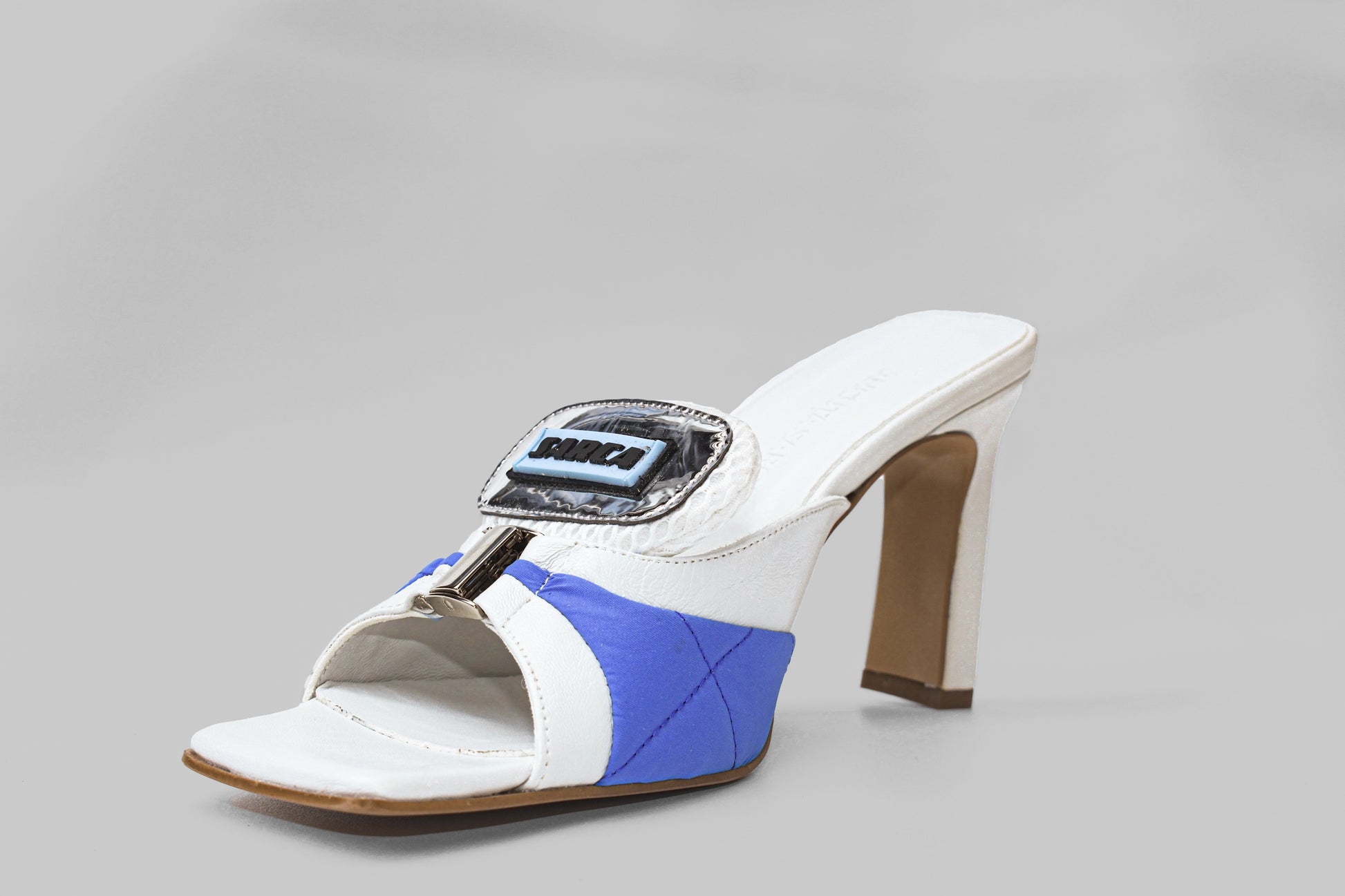 A photo of the diagonal view of Ancuta Sarca Lithium Sandal, white and blue with 9CM HEEL, PANELLED DESIGN, SQUARE TOE, PADDED MESH TONGUE WITH LOGO PATCH, SILVER TONE HARDWARE, MADE IN ITALY
