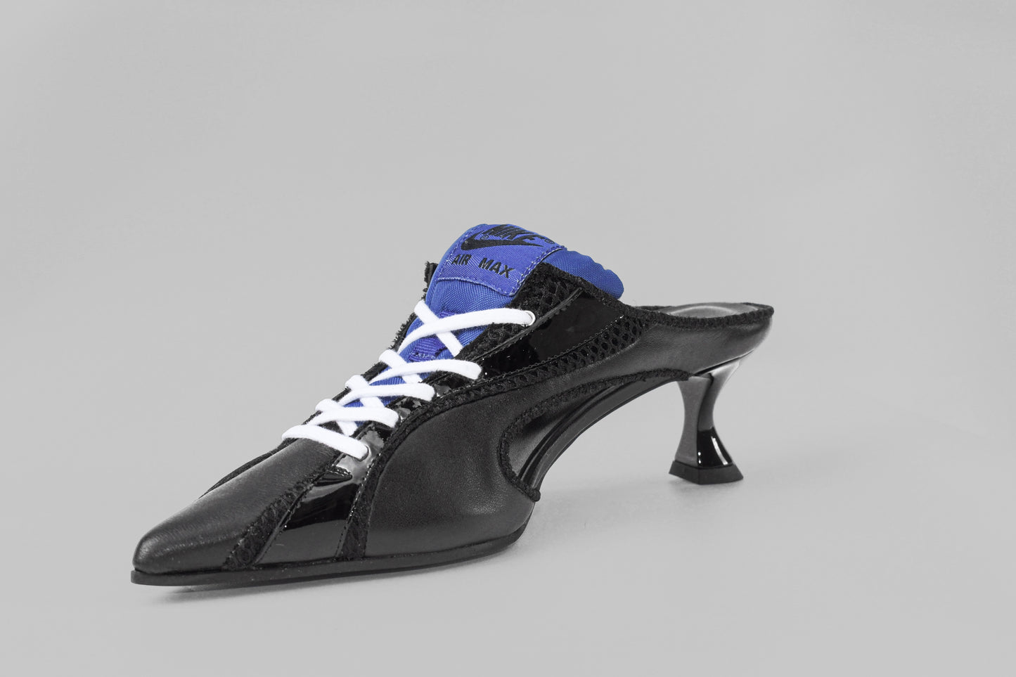 A photograph of the diagonal view of Ancuta Sarca Moto' Mule Black, 5CM SCULPTED HEEL, SLIP-ON STYLE, PANELLED DESIGN, FAUX LACE-UP FASTENING, LOGO PATCH MESH TONGUE, BRANDED FOOTBED POINTED TOE, MADE IN ITALY