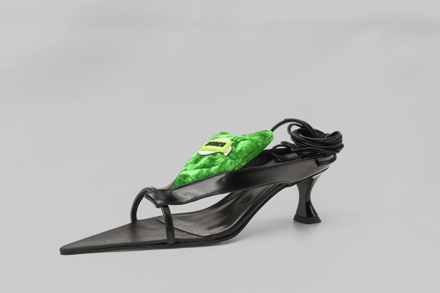 A photograph of diagonal view of Ancuta Sarca Tallulah Sandal shoe in BLACK AND GREEN, SELF-TIE ANKLE STRAP FASTENING, PADDED LOGO PATCH ON TONGUE, MADE IN ITALY